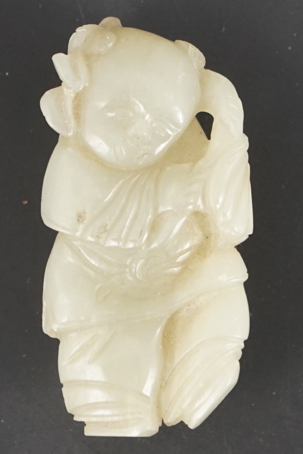 A Chinese celadon jade figure of a boy holding a lotus sprig, 19th century 5.2 cm high